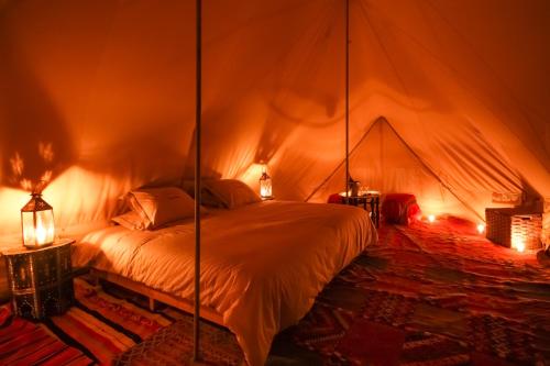 a bedroom with a bed in a tent at Bivouac Exclusif "Les Hommes Bleu"-Dar Azawad in Mhamid