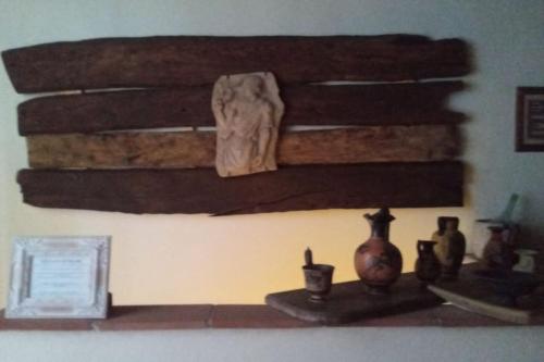 a shelf with vases and books on a wall at Convivio Etrusco in Bassano in Teverina