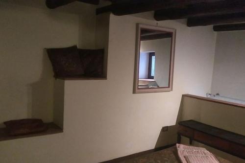 a bedroom with a mirror on the wall and a window at Convivio Etrusco in Bassano in Teverina