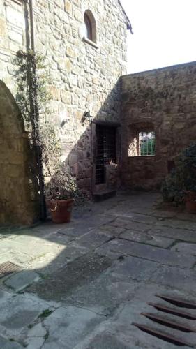 an old stone building with a courtyard in front of it at Convivio Etrusco in Bassano in Teverina