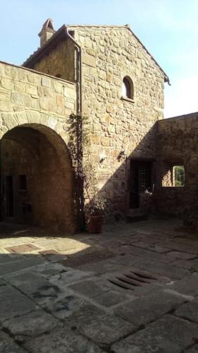 an old stone building with an archway in front of it at Convivio Etrusco in Bassano in Teverina