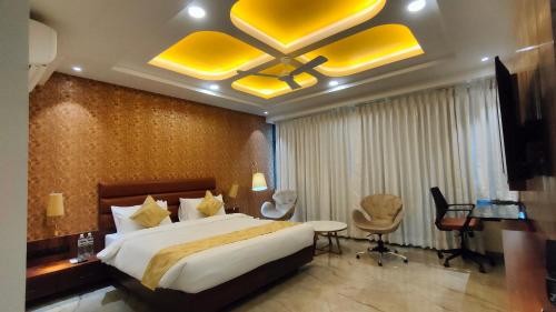 Una habitación de hotel con una cama grande y un escritorio. en Four Petals Executive by LHMS, en Akalkot