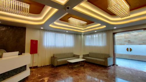 una sala d'attesa con divani e tavolo in un edificio di Four Petals Executive by LHMS a Akalkot