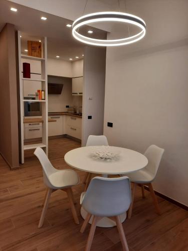 a dining room with a white table and chairs at APPARTAMENTO IL MARZOCCO in Pietrasanta
