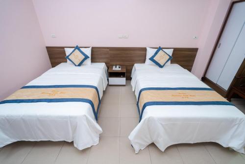 two beds in a hotel room with white and blue at Hoàng Sơn Hải Hotel in Lạng Sơn