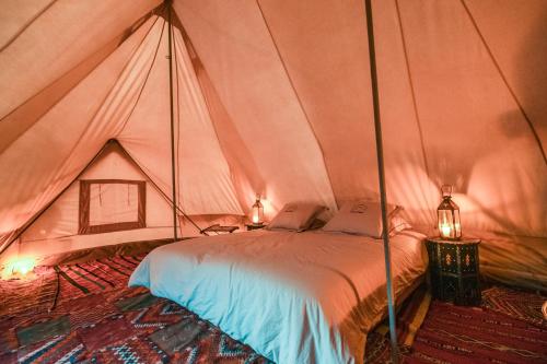 a bedroom with a bed in a tent at Bivouac Exclusif "Les Hommes Bleu"-Dar Azawad in Mhamid