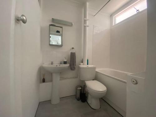 een witte badkamer met een toilet en een wastafel bij 1 Bedroom apartment - City of London in Londen