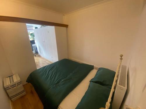 a bedroom with a bed with green sheets and a window at 1 Bedroom apartment - City of London in London
