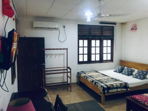 Schlafzimmer mit einem Bett und einem Fenster in der Unterkunft Thisara Pool Resort Kataragama & Yala & Kabiliththa Safari in Kataragama