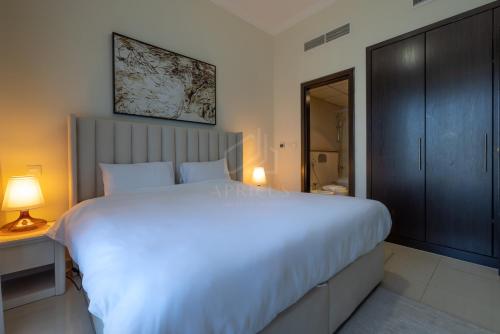 a bedroom with a large white bed and a bathroom at Awesome Marina Canal View 1BD Bay Central Marina in Dubai