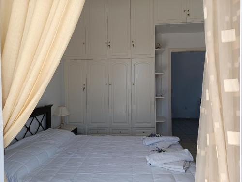 a bedroom with a large bed with white cabinets at Socrates in Elafonisos