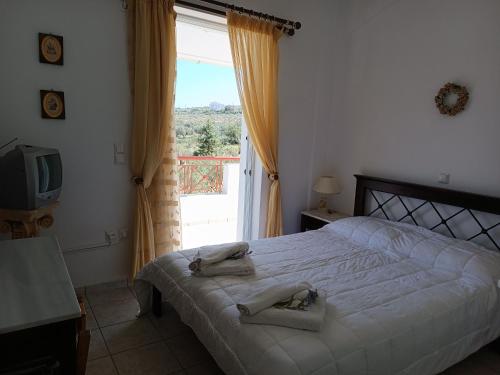 a bedroom with a bed and a window and a television at Socrates in Elafonisos