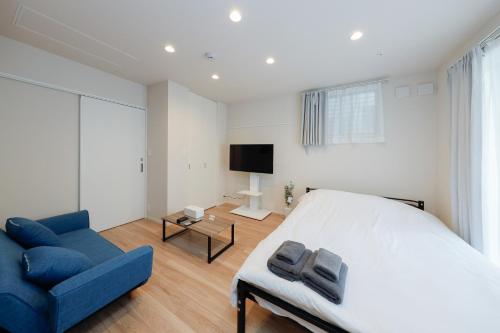 a bedroom with a bed and a blue couch at Higashi Komagata House by Tranova in Tokyo