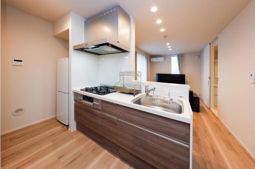a kitchen with a sink and a stove at Higashi Komagata House by Tranova in Tokyo