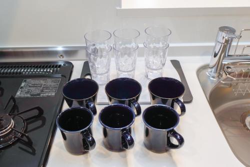 a group of cups sitting on top of a stove at Higashi Komagata House by Tranova in Tokyo