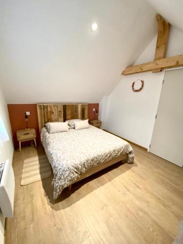ein Schlafzimmer mit einem großen Bett im Dachgeschoss in der Unterkunft La Rose des Vents in Saint-Lunaire