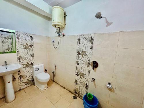 y baño con ducha, aseo y lavamanos. en Kasol Hostel, en Kasol