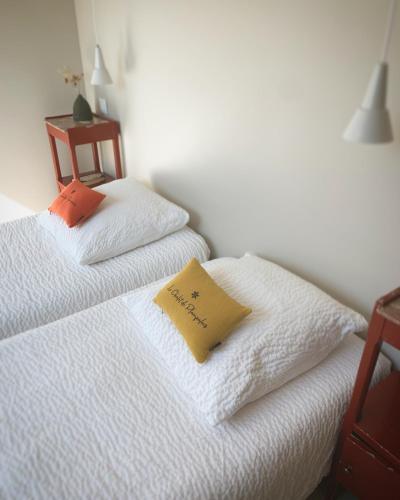 a bedroom with two white beds and a yellow pillow at le chalet de Plainpalais in Les Déserts