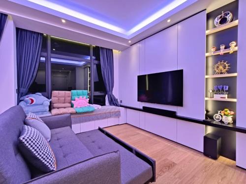a purple living room with a couch and a tv at 4-6pax Seaview Condo 5min Kuantan town in Kuantan