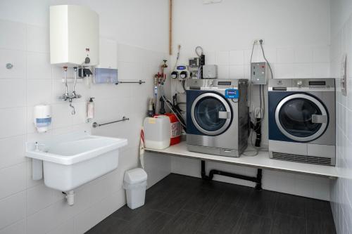 a laundry room with a washing machine and a sink at PM-PremiumAPART Strassgang in Graz