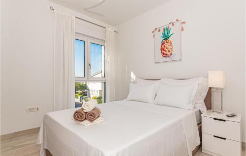ein weißes Schlafzimmer mit einem Bett mit zwei Handtüchern darauf in der Unterkunft Amazing Apartment In Vodice With Jacuzzi in Vodice