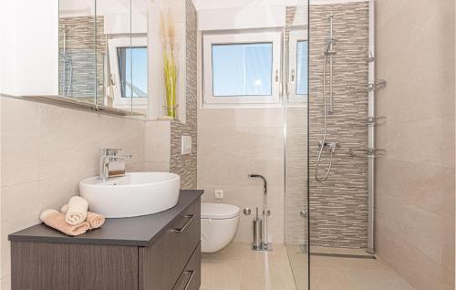 ein Bad mit einem Waschbecken und einer Glasdusche in der Unterkunft Amazing Apartment In Vodice With Jacuzzi in Vodice