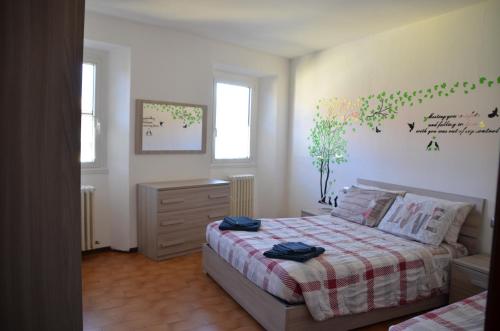 a bedroom with a bed and a dresser at Appartamento Iris in Bellano