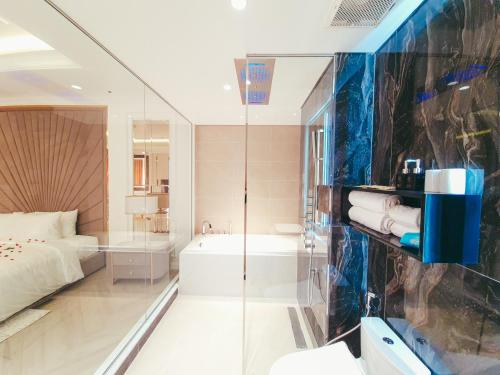 a bathroom with a shower and a tub and a bed at Phúc Thắng Hotel in Phú Quốc