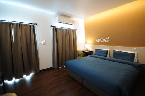 a bedroom with a bed with blue pillows at Jeboutiquelangsuan hotel in Lang Suan