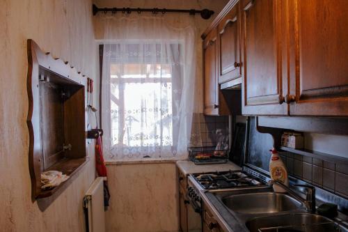 a small kitchen with a sink and a window at ZOLI'BÁ Apartman in Gyöngyösfalu