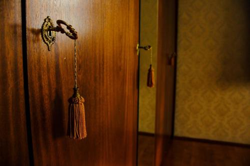 a closed door with a tassel hanging from it at ZOLI'BÁ Apartman in Gyöngyösfalu