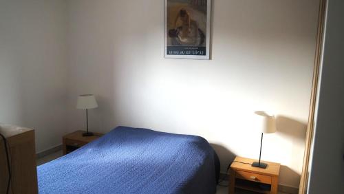 - une chambre avec un lit bleu et 2 tables de chevet dans l'établissement Les Grenadines du samedi au samedi, à Antibes