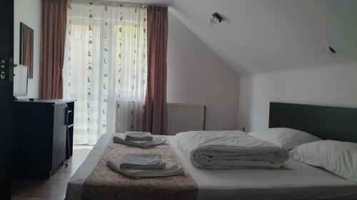 a bedroom with a bed with towels on it at Pensiunea Paula in Moieciu de Sus