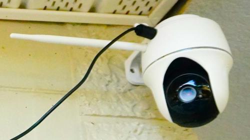 a white security camera with a blue eye on a wall at Summer Breezes in Holiday
