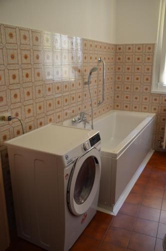 a washing machine in a bathroom with a tub at Appartamento Iris in Bellano