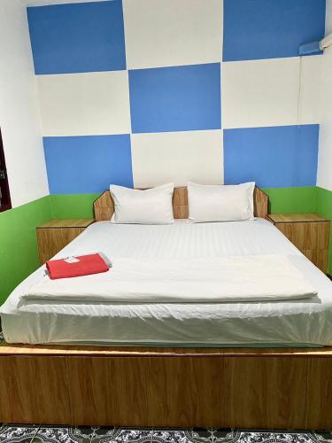un letto con due cuscini e una cartellina rossa sopra di คีรีเฮ้าส์ a Ban Nong Bua