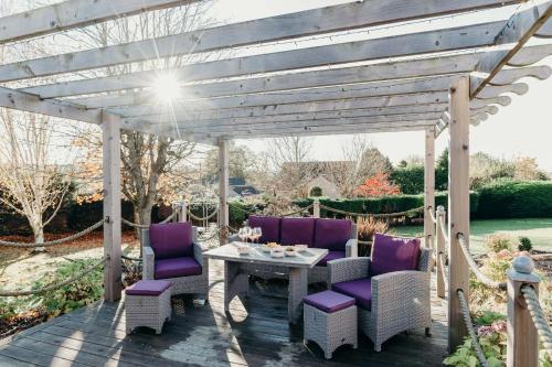 a wooden pergola with purple chairs and a table at Large Holiday Home perfect for family gatherings in Angus