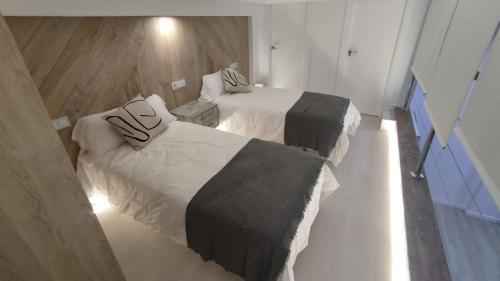 2 Betten in einem Hotelzimmer mit in der Unterkunft vivienda turística los Robles in Tudela