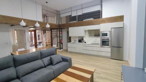 ein Wohnzimmer mit einem Sofa und einer Küche in der Unterkunft vivienda turística los Robles in Tudela