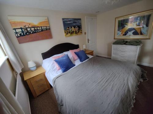a bedroom with a bed and paintings on the wall at Stunning 1 bedroom apartment over looking river in Rye