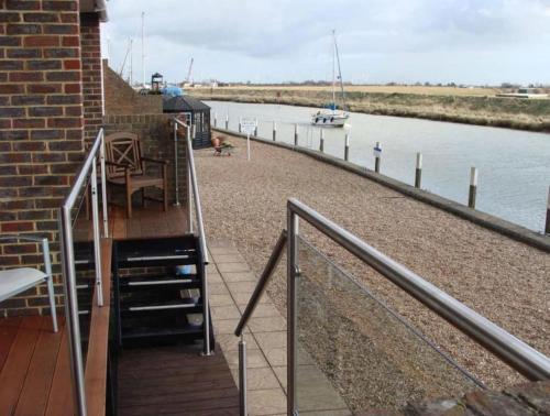 a stairway leading to a balcony with a view of a river at Stunning 1 bedroom apartment over looking river in Rye