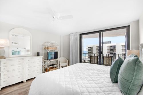 a bedroom with a white bed and a large window at Mainsail 176 in Destin