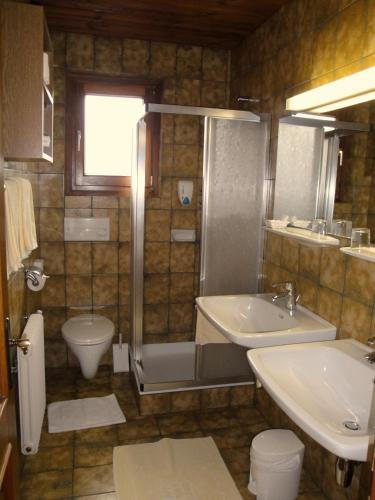 a bathroom with a sink and a shower and a toilet at Pension & Appartement Steinwender in Bad Kleinkirchheim