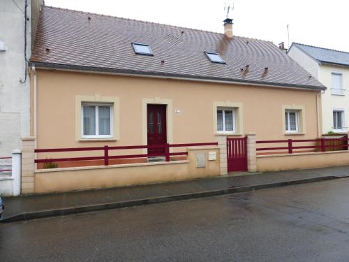 une maison jaune avec une clôture rouge dans une rue dans l'établissement Chambre le Mans, au Mans