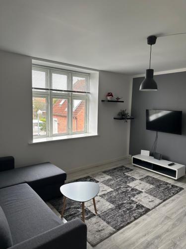 a living room with a couch and a table at Storebælt Apartament in Korsør