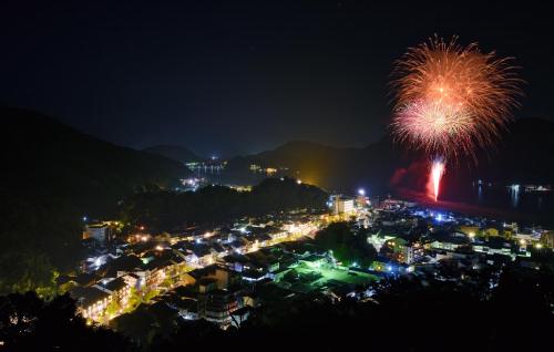 a fireworks display over a city at night at Asagiriso in Toyooka
