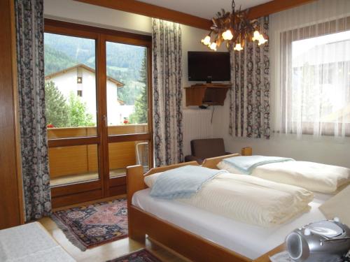 a bedroom with two beds and a large window at Pension & Appartement Steinwender in Bad Kleinkirchheim