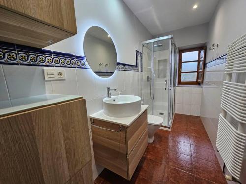 y baño con lavabo, aseo y espejo. en 10A04 Casa Petacos, en Pravia