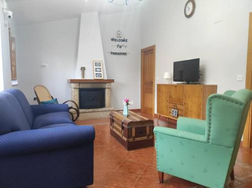 a living room with two blue chairs and a tv at 10A04 Casa Petacos in Pravia