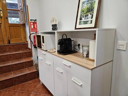 a kitchen with a counter with a microwave and stairs at 10A04 Casa Petacos in Pravia